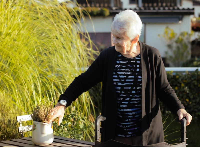 Glückliche ältere Dame fühlt sich sicher mit dem Hausnotruf-Armband von novaura